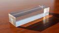 Transparent rectangular acrylic prism rests on a wooden surface Royalty Free Stock Photo