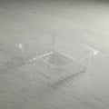 A transparent, rectangular plastic container is placed on a light gray, textured concrete Royalty Free Stock Photo