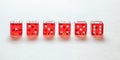 Transparent red craps dices arranged on white board, showing all numbers from one to six. Front view