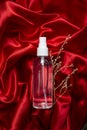 transparent sanitizer spray bottle levitating on red satin background Royalty Free Stock Photo