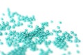 Transparent seed beads aquamarine color scattered on a white surface close-up Royalty Free Stock Photo