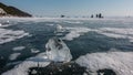 A transparent shard of ice lies on the frozen lake.