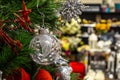 Transparent silver shiny ball on the Christmas tree against the background of defocus shelves in the store. Concept Christmas Royalty Free Stock Photo