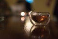 Transparent small glass of Chinese black tea on a table, shot co
