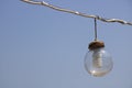 Transparent sphere and light bulb with savings inside. Hanging with cable