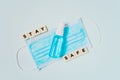 Transparent spray bottle of alcohol on surgical mask with stay safe word on blue background ,new normal lifestyle concept