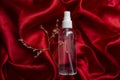 transparent spray bottle on red satin background Royalty Free Stock Photo