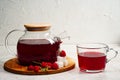 Transparent teapot and cup with red sweet tea with raspberries. Detox berries antioxidant home health drink. Copy space Royalty Free Stock Photo