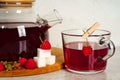 Transparent teapot and cup with red sweet tea with raspberries. Detox berries antioxidant home health drink. Copy space Royalty Free Stock Photo