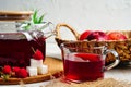 Transparent teapot and cup with red tea with raspberries and apples. Detox antioxidant home health drink. Copy space Royalty Free Stock Photo