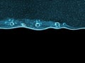 Transparent turquoise thick gel with bubbles on black background Royalty Free Stock Photo