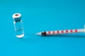 Transparent vial container with liquid medicine near small insulin syringe with capacity 1 CC and small needle on blue background Royalty Free Stock Photo