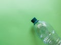 Transparent water pet plastic bottle on green background. Concept of garbage separate collection, plastic waste and recycling. Be