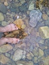 Transparent water surface with human feet from top view