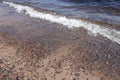 A wave of water rolls over the sandy beach. Royalty Free Stock Photo