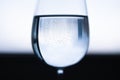 Transparent wine glass with water in the middle. Blue black white blurred background. Small Royalty Free Stock Photo