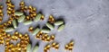 Transparent yellow gel capsules and green tablets on a grey concrete background. The concept of a healthy lifestyle Royalty Free Stock Photo