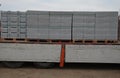 Transport of concrete bricks with for house foundations or fencing. pallets with gray bricks are unloaded from the body of the car