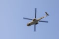 Transport helicopter in flight, with big propeller blades seen from below against Blue sky. Empty space for text. Royalty Free Stock Photo