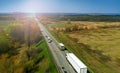 Transport logistics background with trucks on a highway between fields Royalty Free Stock Photo