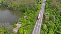 Transport logistics background with trucks on a highway between green forest and lake Royalty Free Stock Photo