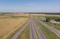 Top view of trucks and cars moving along the asphalt road along the fields. Royalty Free Stock Photo