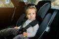 Transport, safety, childhood road trip and people concept. Happy Caucasian cute little baby girl sitting in baby car Royalty Free Stock Photo