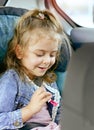 Transport, safety, childhood trip and people concept - close portrait of a smiling little caucasian girl sitting in a car seat in Royalty Free Stock Photo