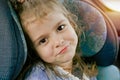 Transport, safety, childhood trip and people concept - close portrait of a smiling little caucasian girl sitting in a car seat in Royalty Free Stock Photo