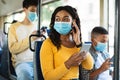 Smiling black woman in facemask listening music in bus Royalty Free Stock Photo