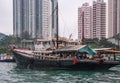 Transport vessel docked in front of tall buildings in harbor of Hong Kong, China