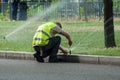 Transportation company employee adjusting automatic sprinklers on tramway line