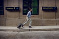 Transportation Concept. Hurrying to Boarding. Smiling Passenger Businessman Running and Pulling Luggage in the Airport Royalty Free Stock Photo