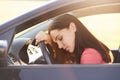 Transportation concept. Tired beautiful woman driver has sleepy expression, stop on road as can`t drive any more, wants to have re Royalty Free Stock Photo