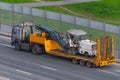 Transportation of equipment for cutting and removing old asphalt pavement for road repair on a truck platform of a truck trailer