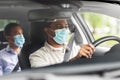 male driver in mask driving car with passenger Royalty Free Stock Photo