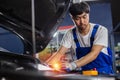 Transportation repair service concept, Repairman auto mechanic Checking battery power of car after has been used inside engine.