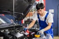 Transportation repair service concept, Repairman auto mechanic Checking battery power of car after has been used inside engine.