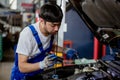 Transportation repair service concept, Repairman auto mechanic using flashlight to check for damage inside engine. man worker