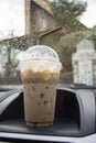 Transportation and vehicle concept - take away cup of iced coffee put on a front console of a car with water drop of raining Royalty Free Stock Photo