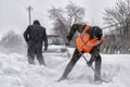 Transportation, winter, people and vehicle concept - closeup of man digging snow with shovel near car Royalty Free Stock Photo