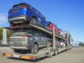 Transporter is waiting to unload the vehicles. New cars are coming Royalty Free Stock Photo