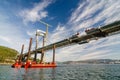 Transporting boat in front of Rande bridge. Cable stayed bridge during lifting the last segment Royalty Free Stock Photo