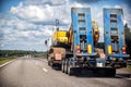 Transporting a heavy excavator in a truck trailer. Highway heavy oversized cargo transportation, industry. Copy space for text Royalty Free Stock Photo