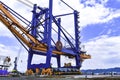 Transporting huge quay crane using self-propelled modular transporter. Moving huge quay crane from ship to harbor.