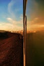 Transsiberian railway: long train making his way throught the desert in mongolia at sunset, as seen from the rear carriage. Royalty Free Stock Photo