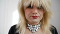 Handsome crossdresser in a beautiful dress and makeup. Drag queen with false breasts. A transvestite in a white wig and Royalty Free Stock Photo