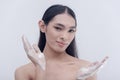 A transwoman advertisement model endorses facial wash for sensitive and oily skin. Posing for the camera with soapy hands.