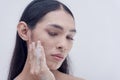 A transwoman removes makeup by washing her face with facial wash for sensitive skin prescribed by dermatologists. Beauty products Royalty Free Stock Photo