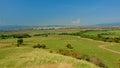 Transylvanian landscape with green fields and city and mountains in the background